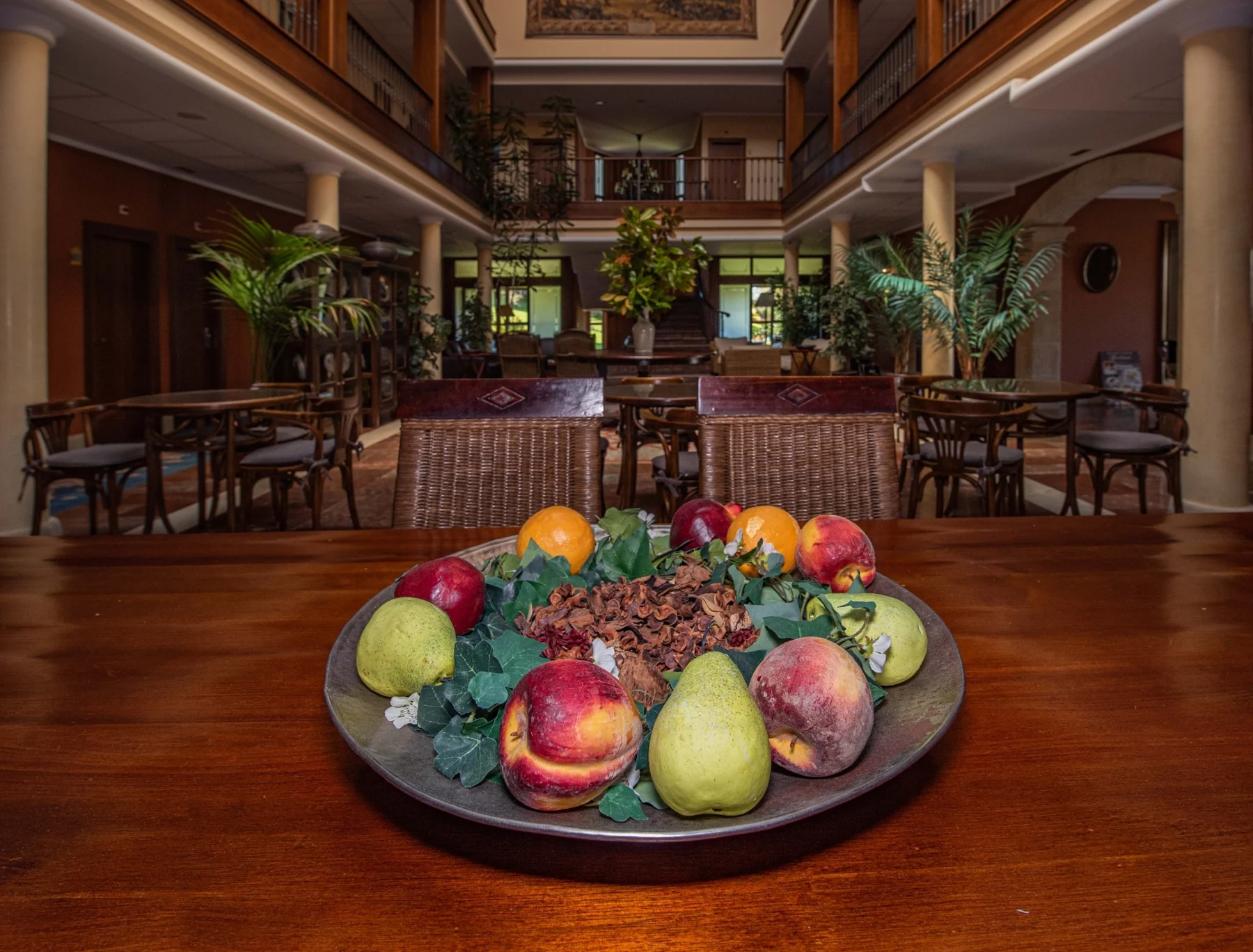 Table with a fruit bowl and plants in the hotel courtyard
