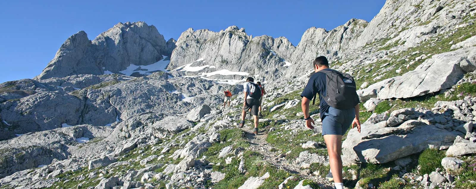 Hikers walking through a limestone mountain landscape