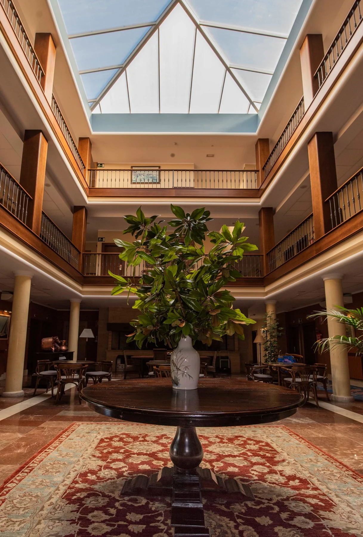 Inner courtyard with a fountain, plants and glazed roof
