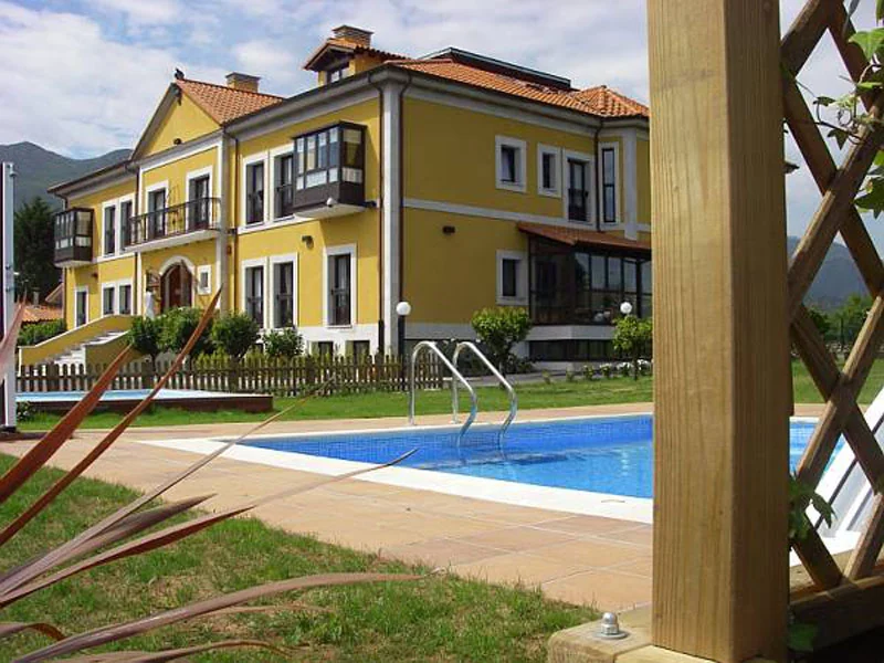 Yellow hotel facade beside the outdoor swimming pool